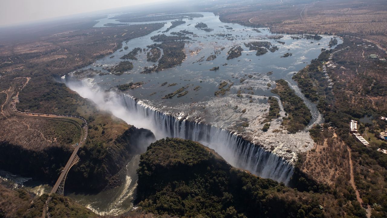 Aerial view of Victoria Falls and the Zambezi gorge, with the road bridge at left