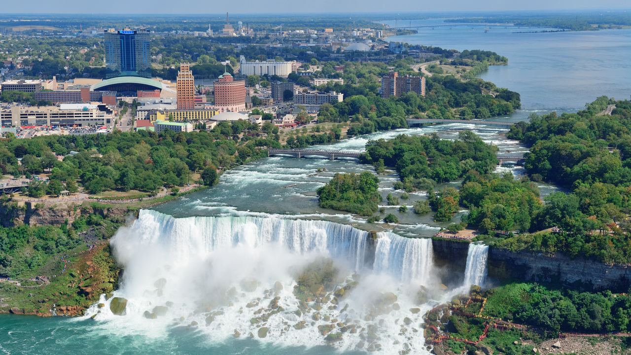 The American Falls and Goat Island at Niagara seen from above, with the Canadian skyline behind
