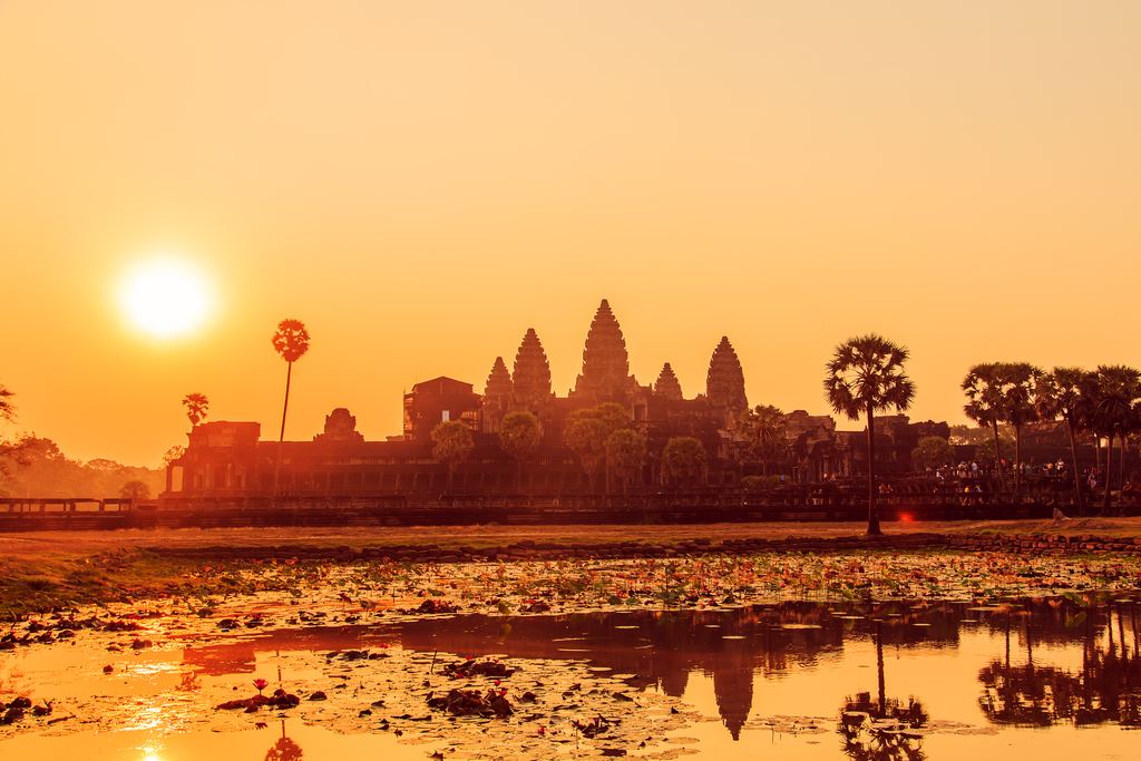 Angkor Wat silhouetted at sunrise across a lotus pond near Siem Reap
