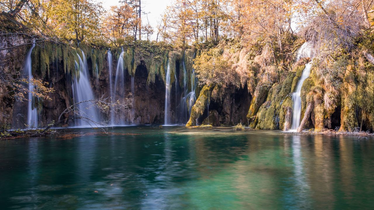 Long exposure of small waterfalls falling into a green lake at Plitvice Lakes National Park, Croatia, in autumn