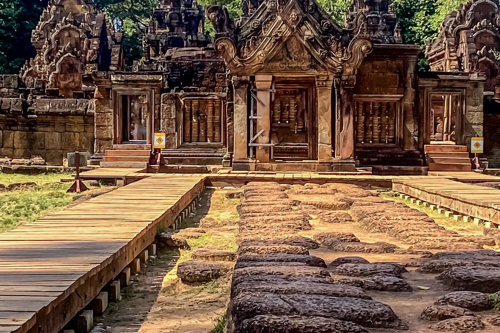 Pink sandstone gateway and shrines of Banteay Srei temple near Siem Reap with a stone path in front