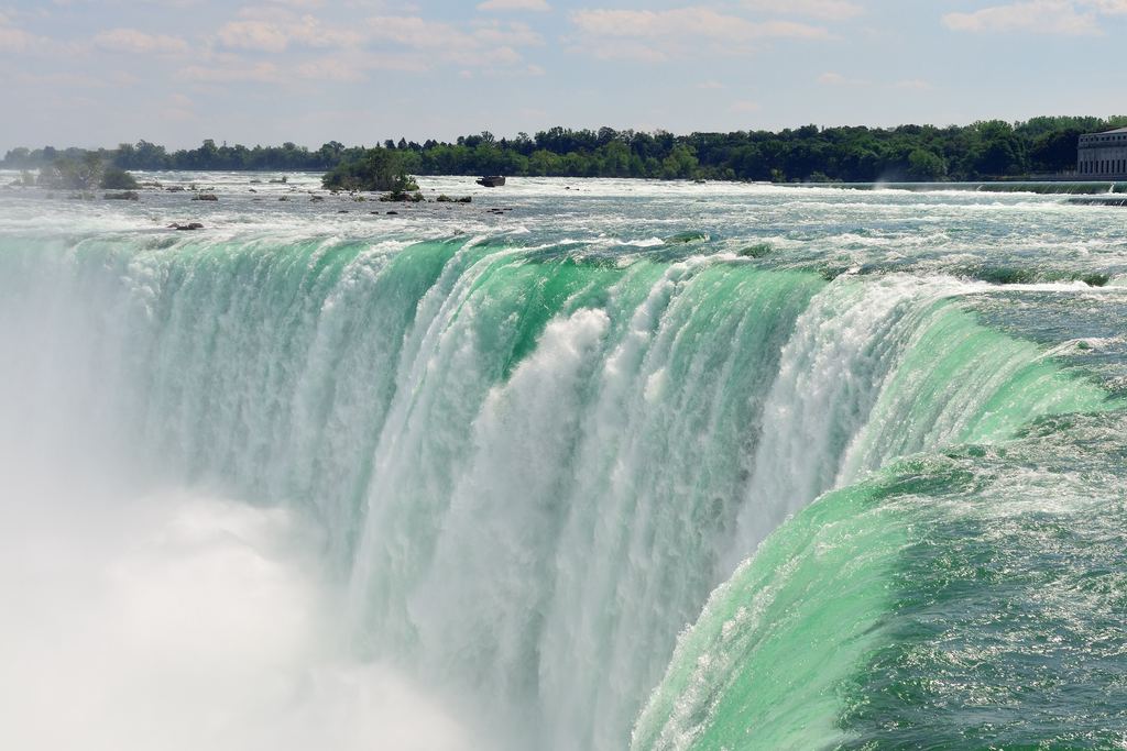 Crest of the Horseshoe Falls at Niagara, green water curving over the brink into a cloud of mist