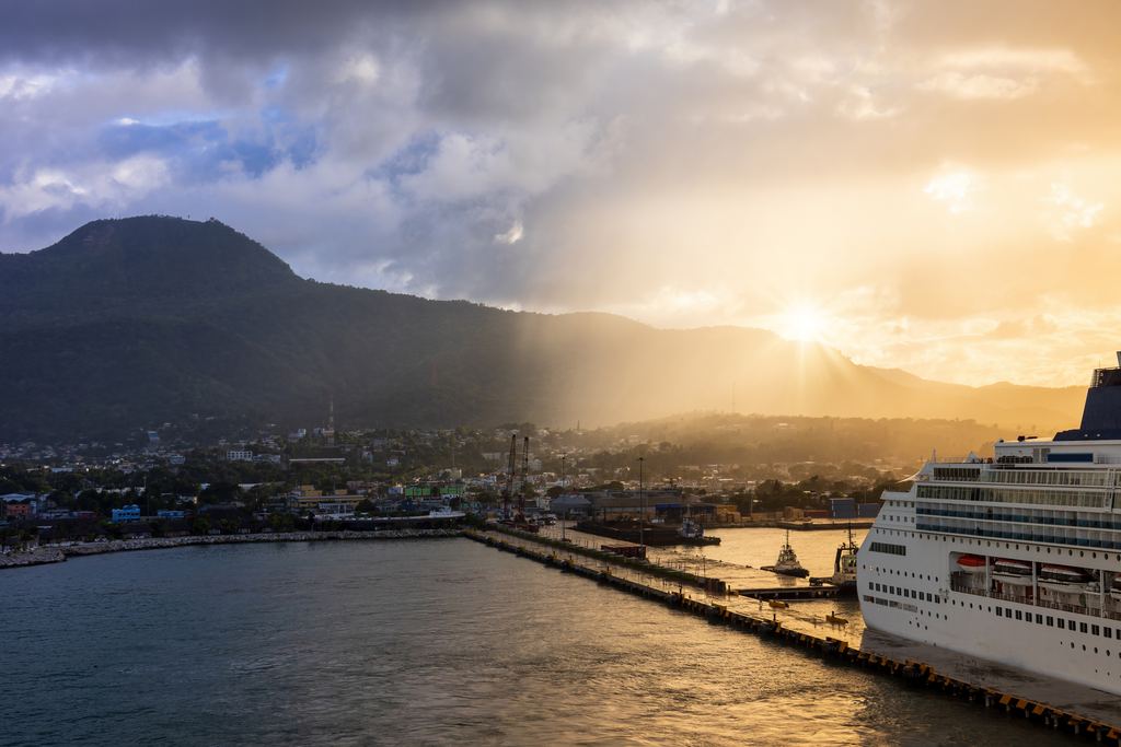 Cruise ship alongside the pier at Puerto Plata at sunset, with the mountain behind the port