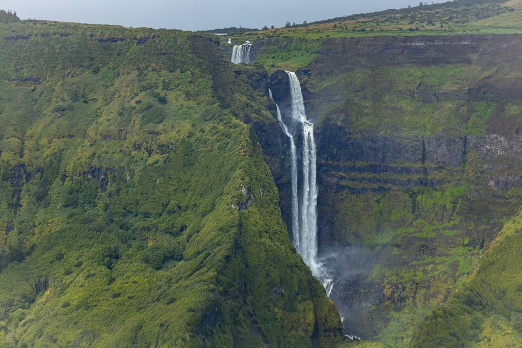 Two-tier waterfall on a steep green cliff on Flores island in the Azores