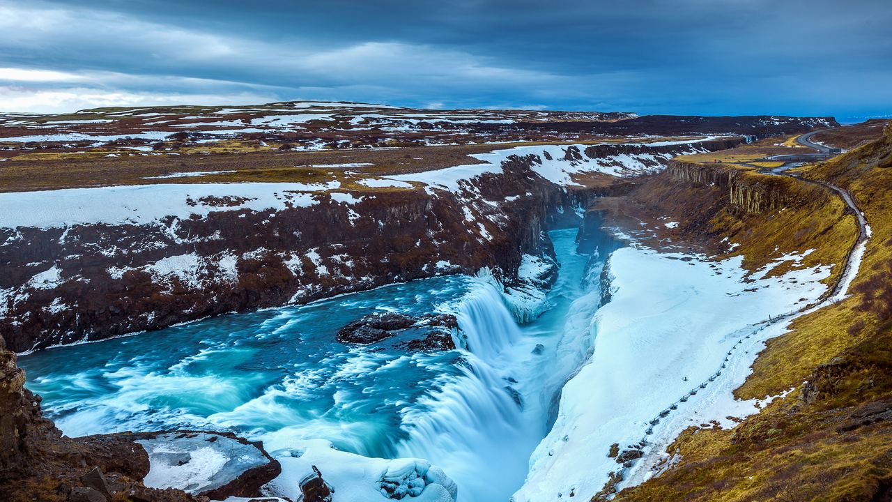 Gullfoss in two drops, with blue ice and snow along the canyon rim in Iceland
