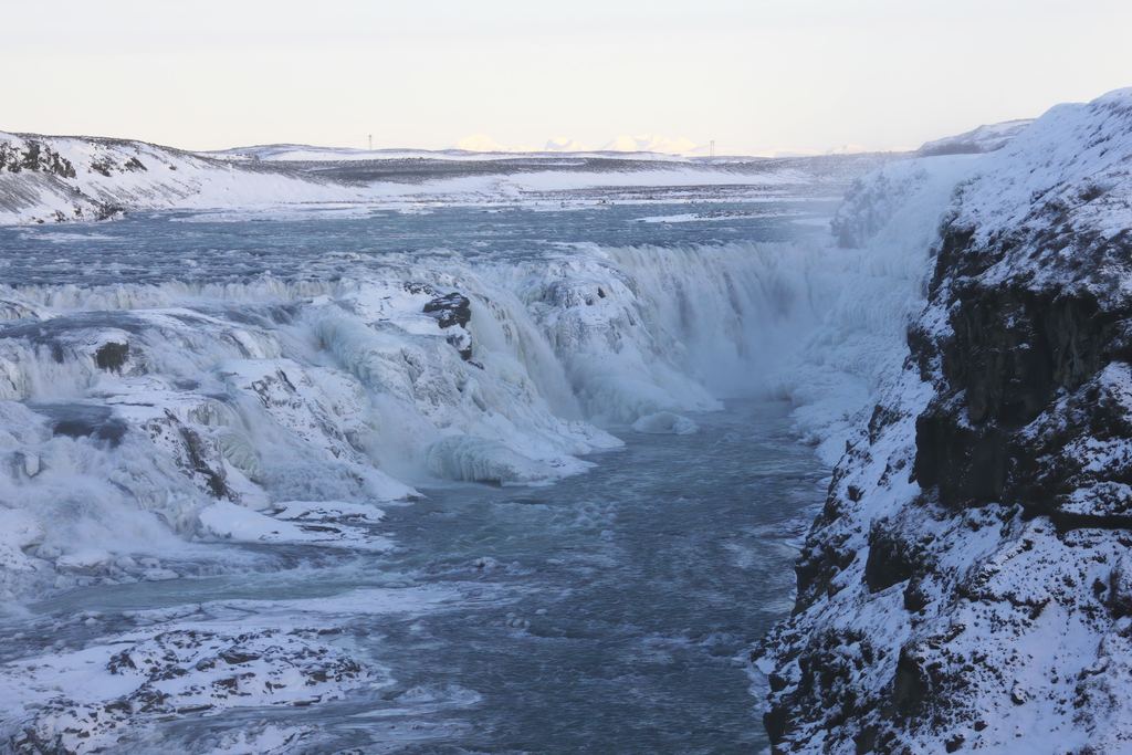 Gullfoss in Iceland in winter, with ice-covered banks and open water in the channel