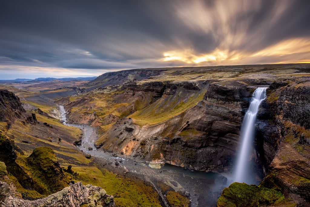 Háifoss waterfall dropping into a wide canyon in the Icelandic highlands under a streaked sky