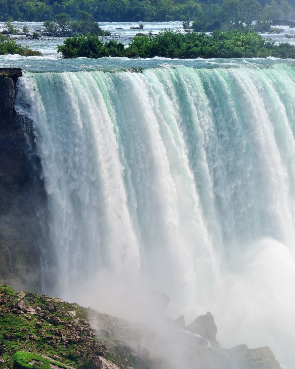 Close-up of the Horseshoe Falls curtain at Niagara with rocks and mist at its foot