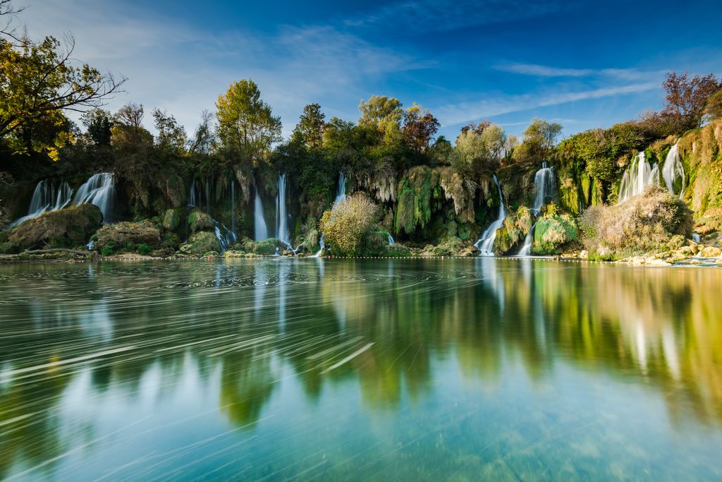 Long exposure of the Kravica Waterfalls with mirror-flat water in front, Bosnia and Herzegovina