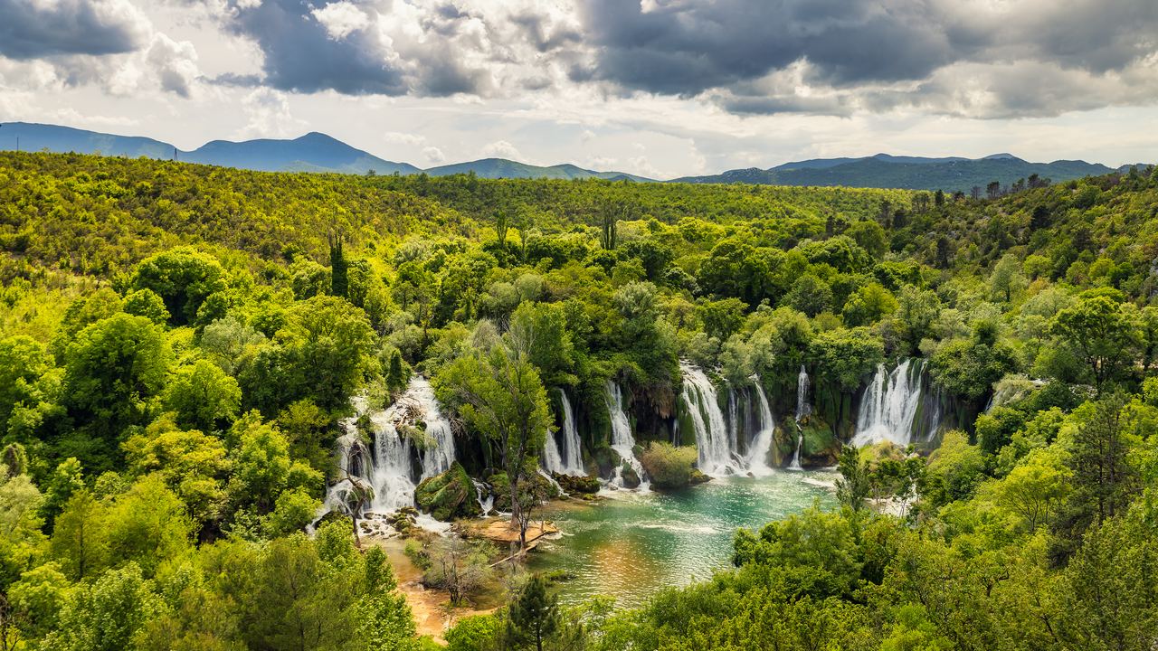 The Kravica Waterfalls seen from a viewpoint over green hills, Bosnia and Herzegovina