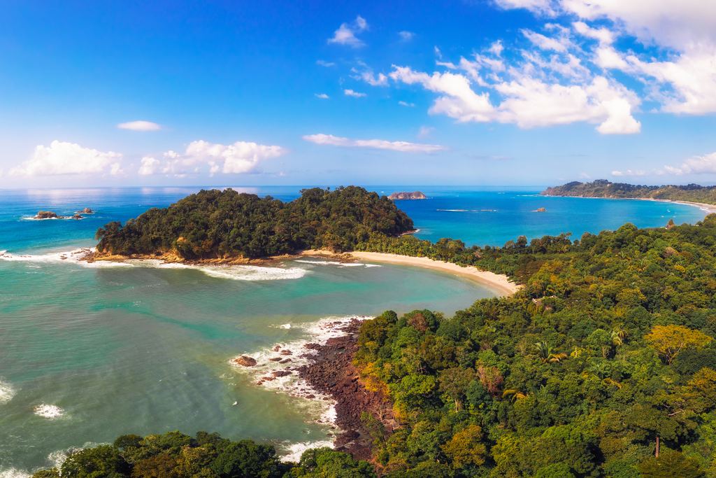 Aerial view of a beach and forested headland in Manuel Antonio National Park, Costa Rica