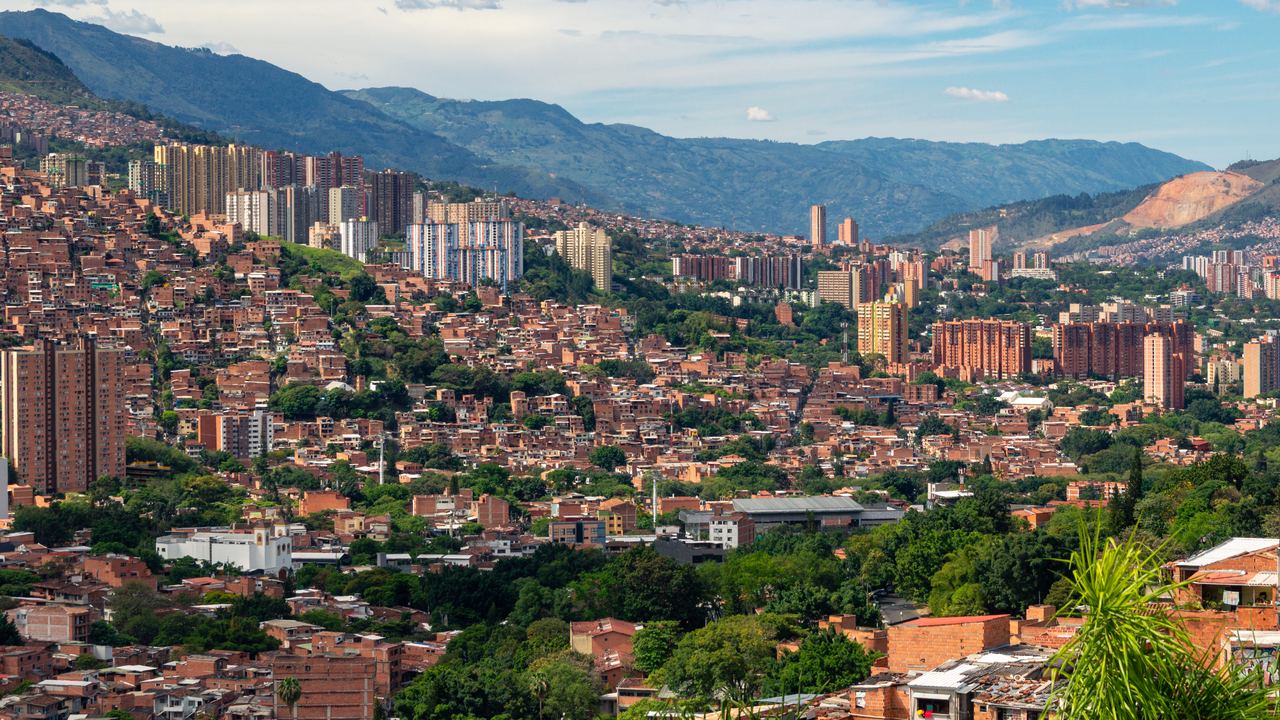 Hillside neighbourhoods of Medellín with green mountains behind the city