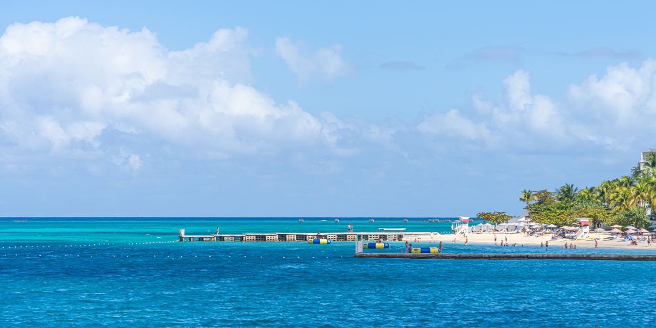 Pier and beach on the Montego Bay waterfront under a deep blue Caribbean sky