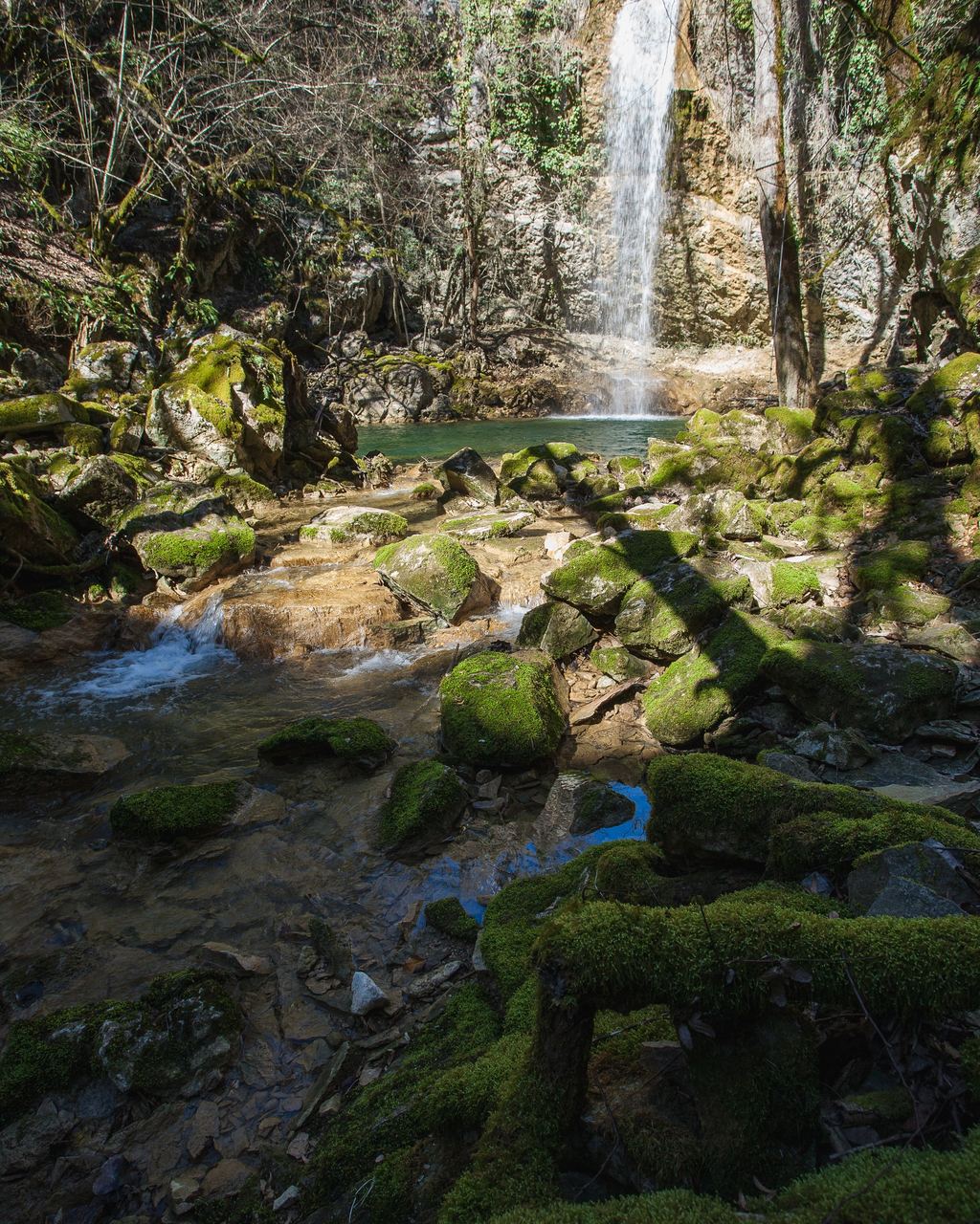 A waterfall behind boulders and stones thickly covered with green moss at Butori in Istria, Croatia