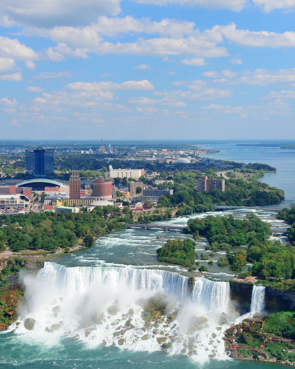 Aerial view of Niagara Falls with the river flowing away from the falls between wooded banks