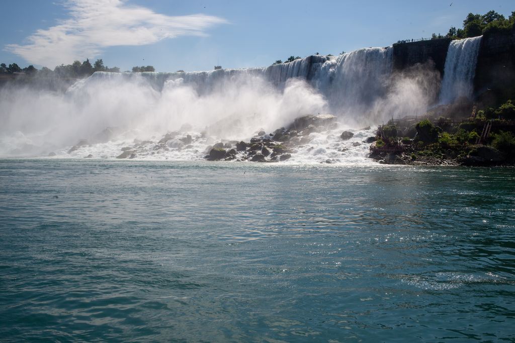 Niagara Falls with green foliage in the foreground under a blue sky