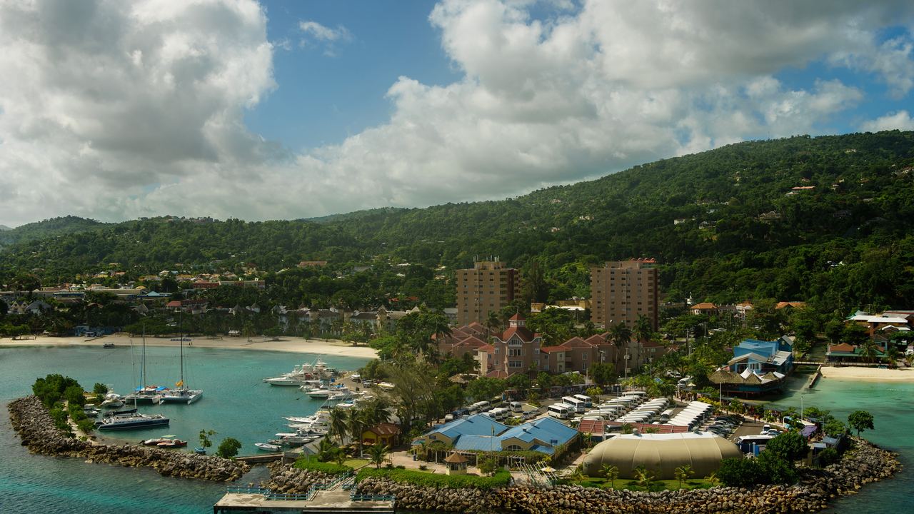 Marina and resort on a small peninsula below green hills at Ocho Rios, Jamaica