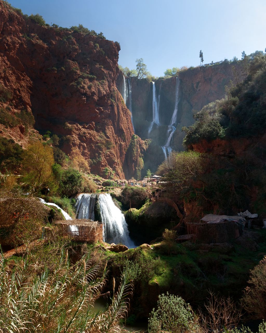 Ouzoud waterfalls falling from a plateau of olive groves into a red rock gorge