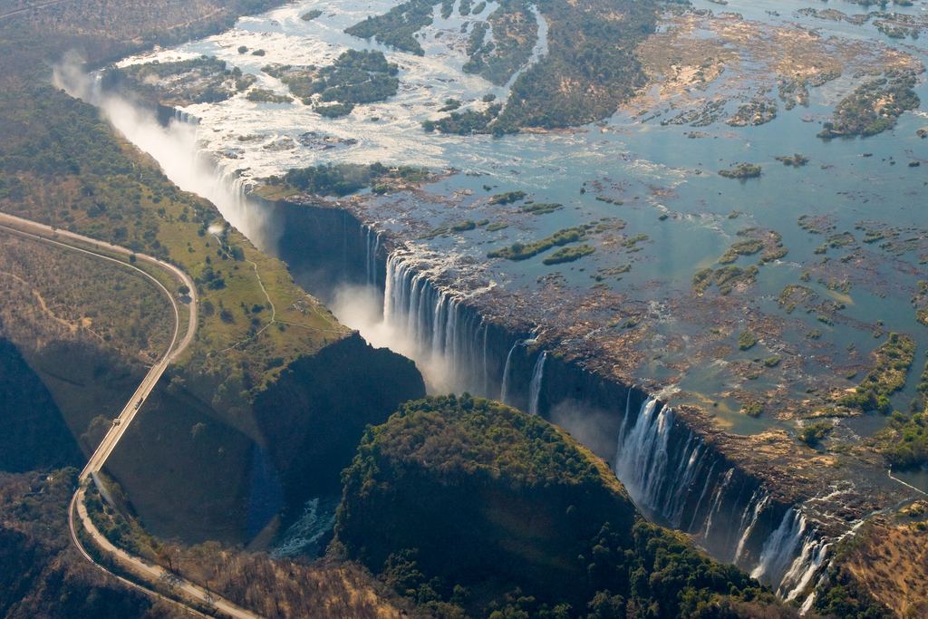 Rainbow arching through the spray over the edge of Victoria Falls, seen from above