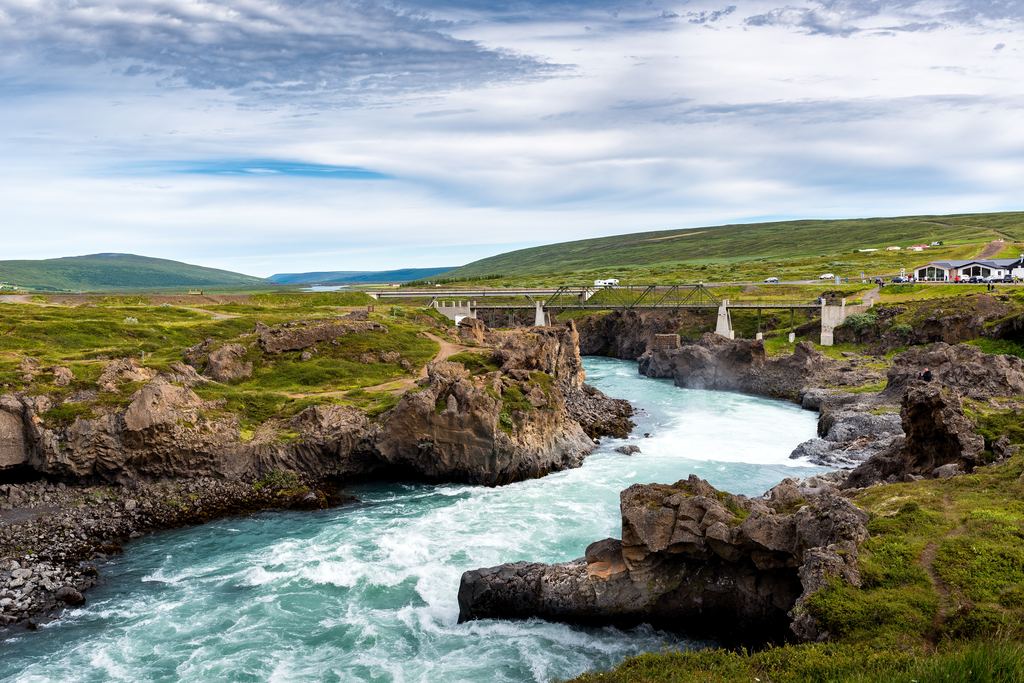 The Skjálfandafljót river rapids below Goðafoss, with a bridge crossing in the distance