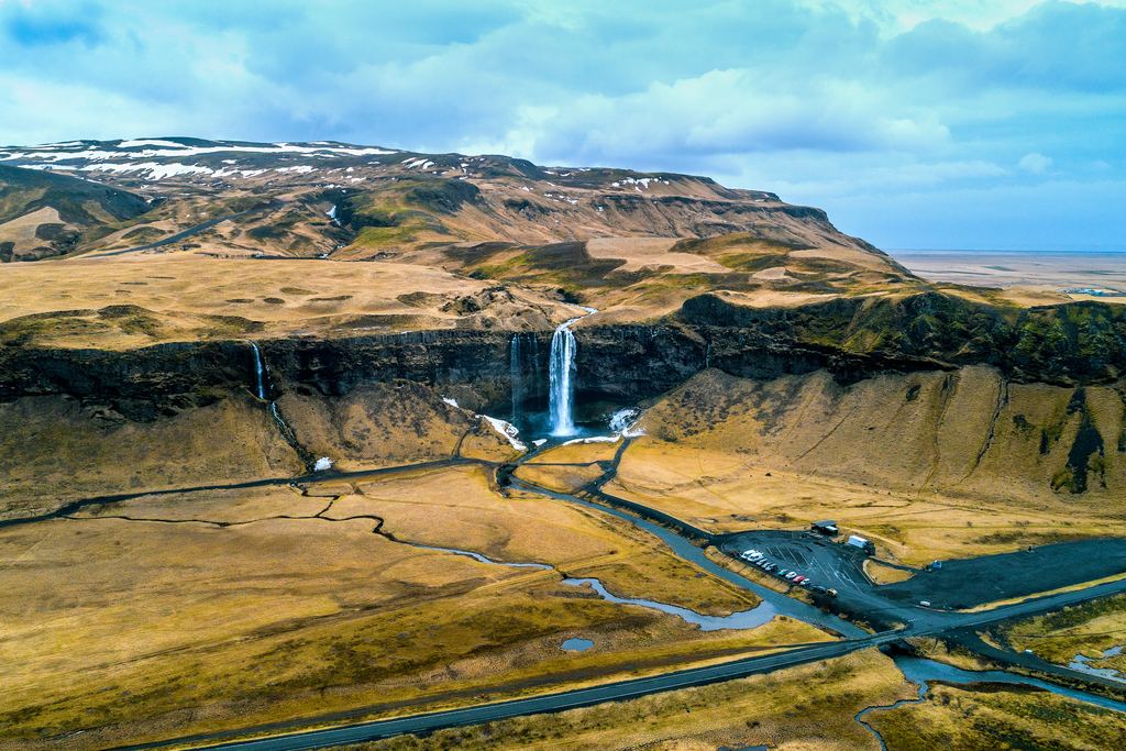 Aerial view of Seljalandsfoss with the road and car park below the cliff