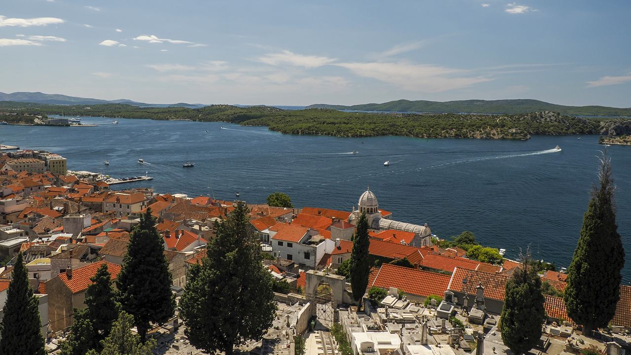 Red roofs of Šibenik with the cathedral dome and the bay beyond, Croatia