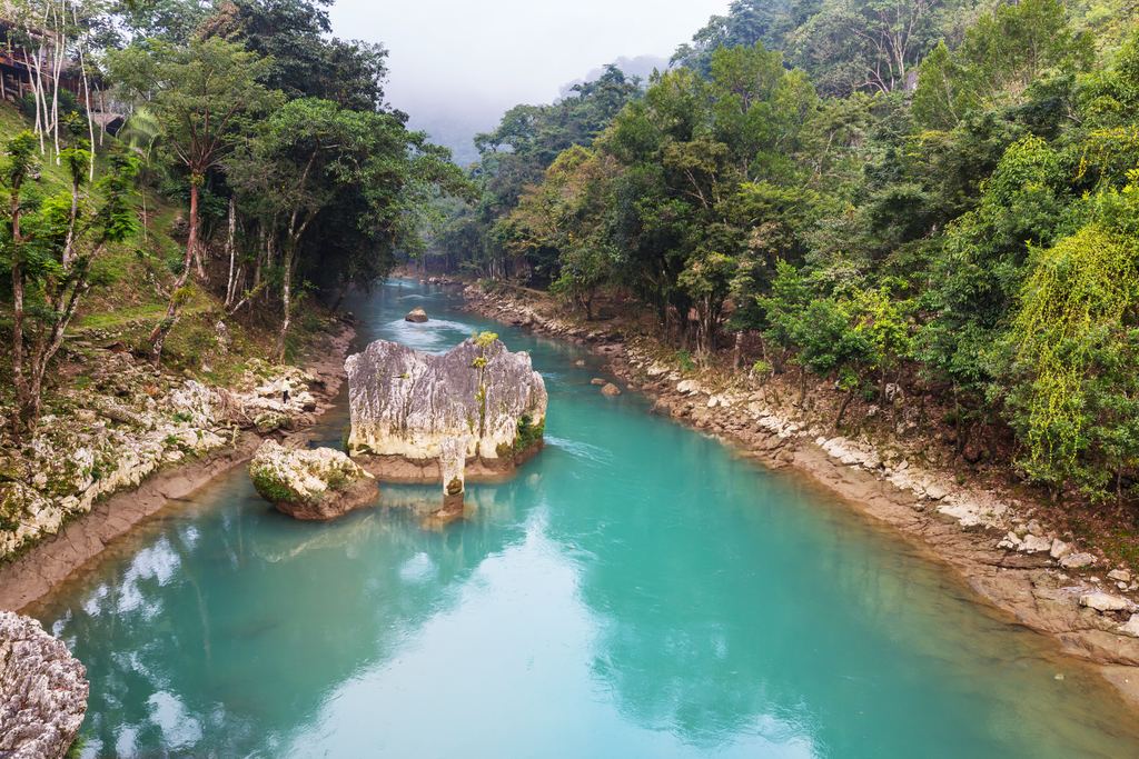 Turquoise river between rocky banks in a Costa Rican forest
