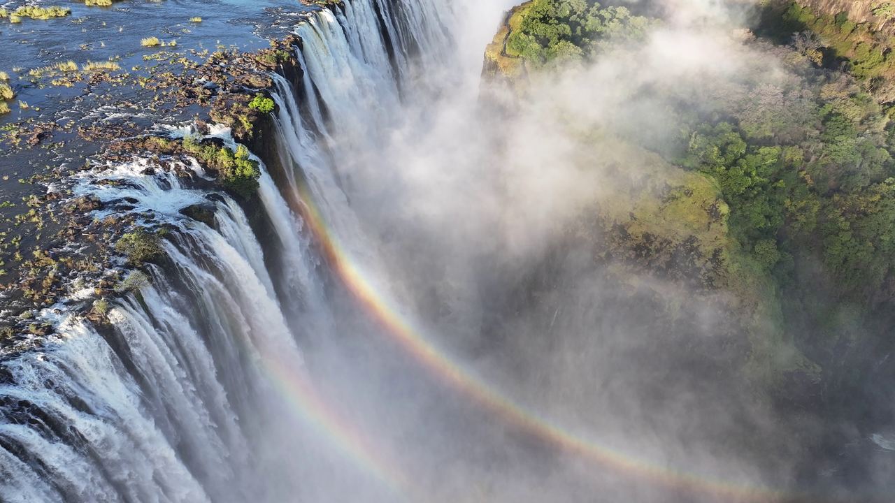Aerial view of Victoria Falls with a rainbow over the spray, on the border of Zambia and Zimbabwe