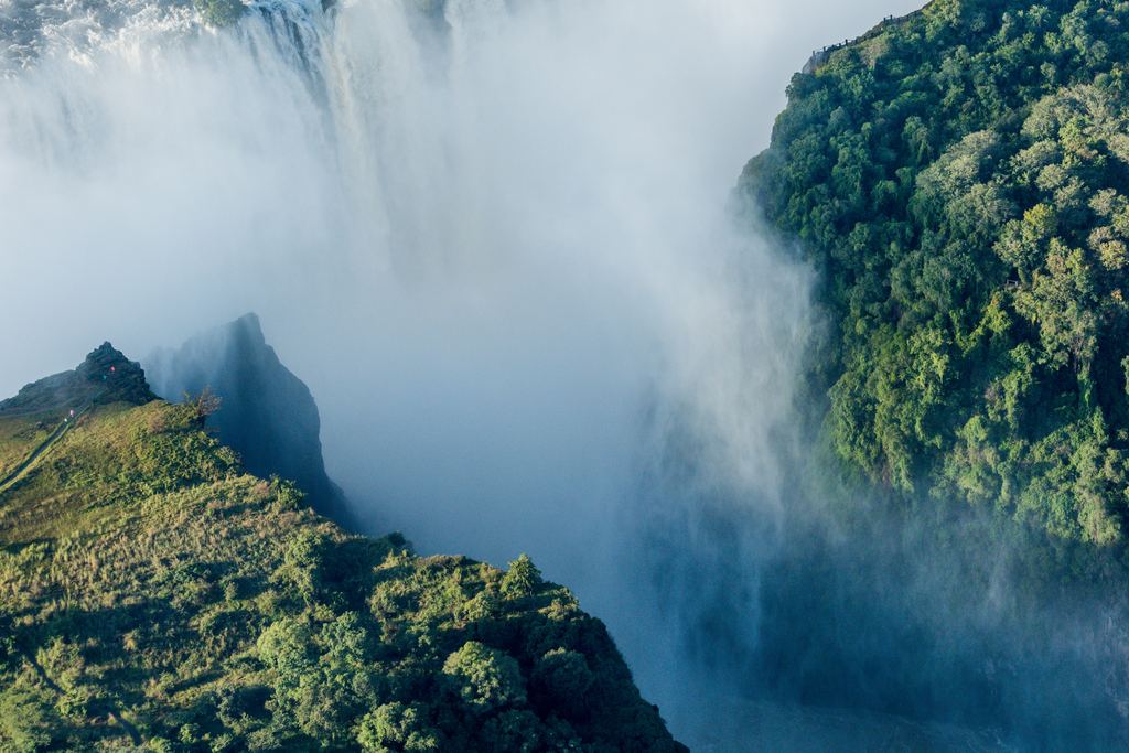 Aerial view of Victoria Falls with mist over the gorge and the Victoria Falls Bridge at the bottom of the frame