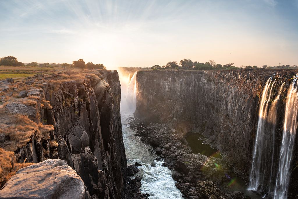 Victoria Falls wall and gorge at sunrise with thin streams of water on the right