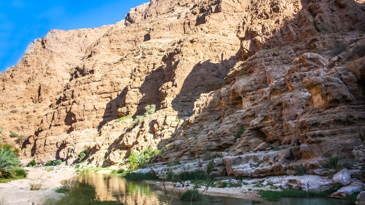 Canyon walls and a green pool in Wadi Shab, Oman