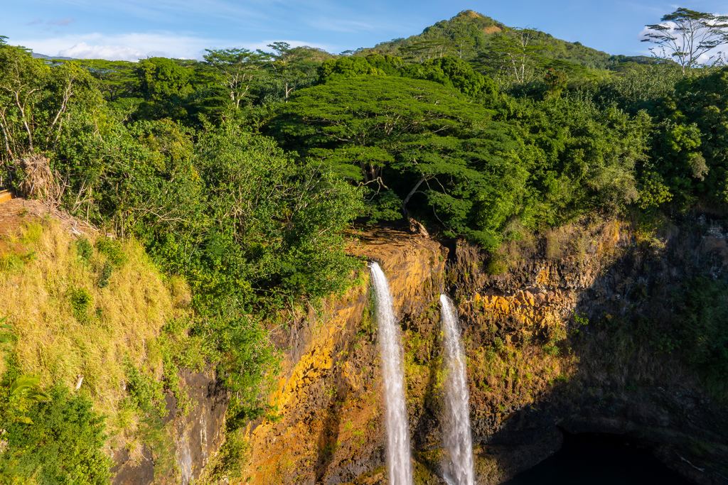 Aerial view of the twin streams of Wailua Falls dropping over a ledge on Kauai, Hawaii