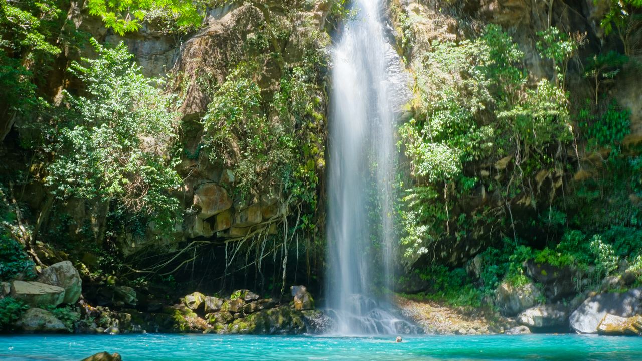 Waterfall falling into a turquoise pool in Rincón de la Vieja National Park, Costa Rica